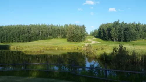 golf course scene with a pond in foreground